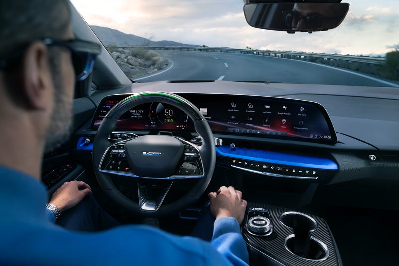 Front View of the 2026 OPTIQ-V Driving Through the Dusk Utilizing its Headlights | Bob Johnson Cadillac in ROCHESTER NY